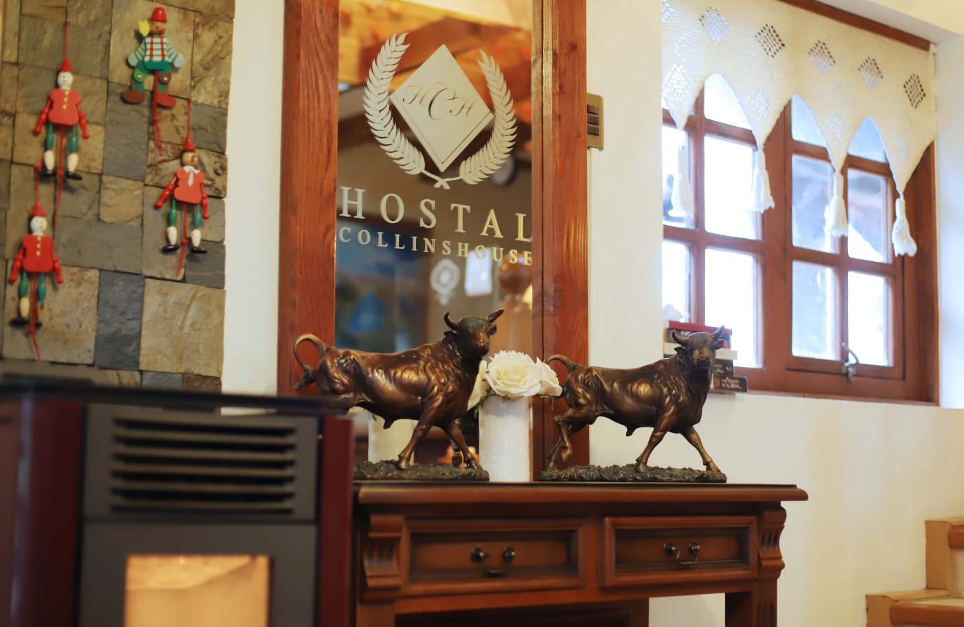 Recepción del Hostal Collins House con el escudo de la casa grabado en el vidrio de la entrada