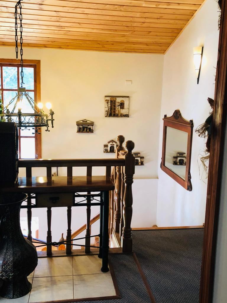 Balcón de madera del hostal rodeado de árboles con follaje otoñal