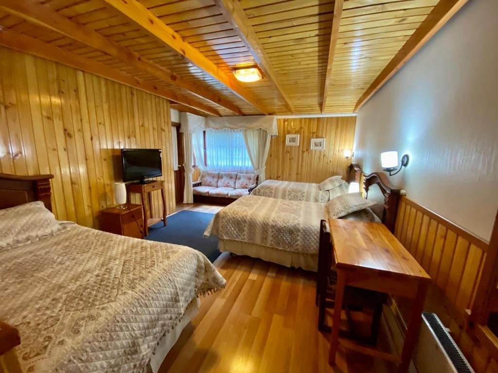 Habitación triple con tres camas y living